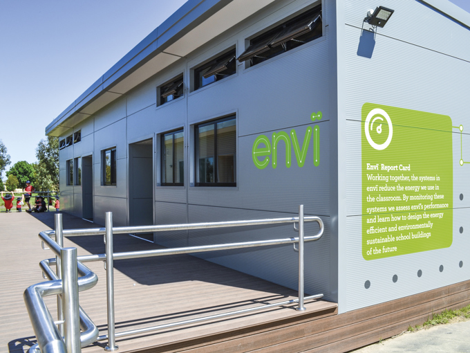 Moderne modulopbygget skolebygning med små åbne vinduer i ydervæggen og en handicapvenlig rampe.